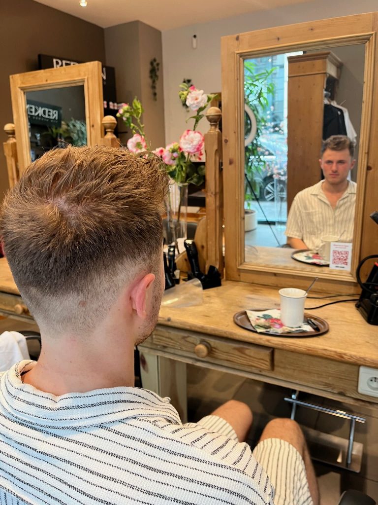 Coiffure masculine stylisée au salon Shine Design, mettant en avant un look moderne et soigné pour les hommes.