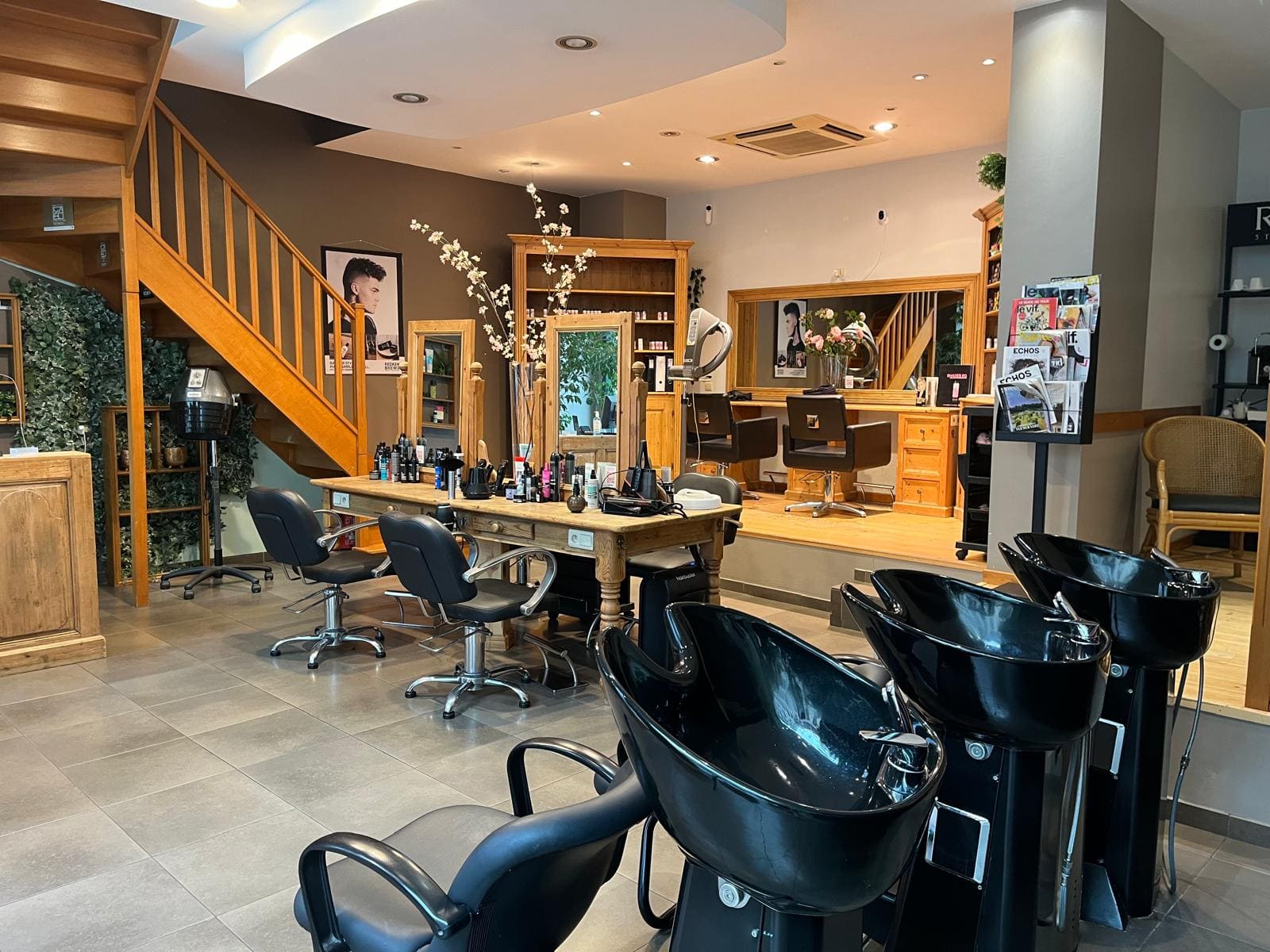 Vue intérieure du salon de coiffure Shine Design à Bruxelles, montrant des fauteuils élégants et une ambiance moderne.